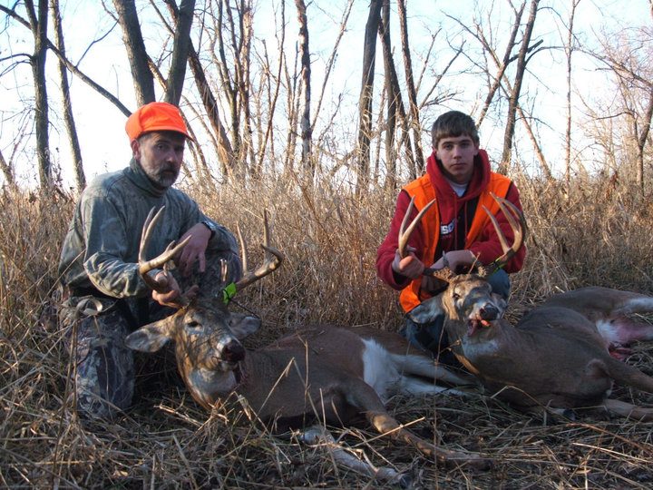 Two men posing with two dead deer
