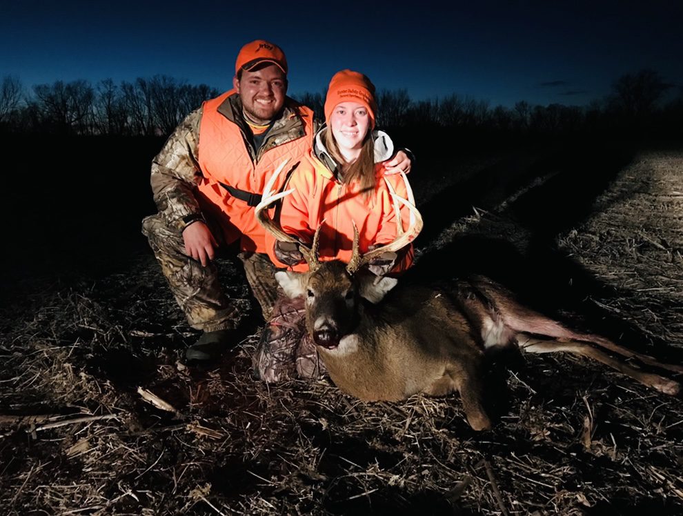 A man and a woman posing with a dead deer